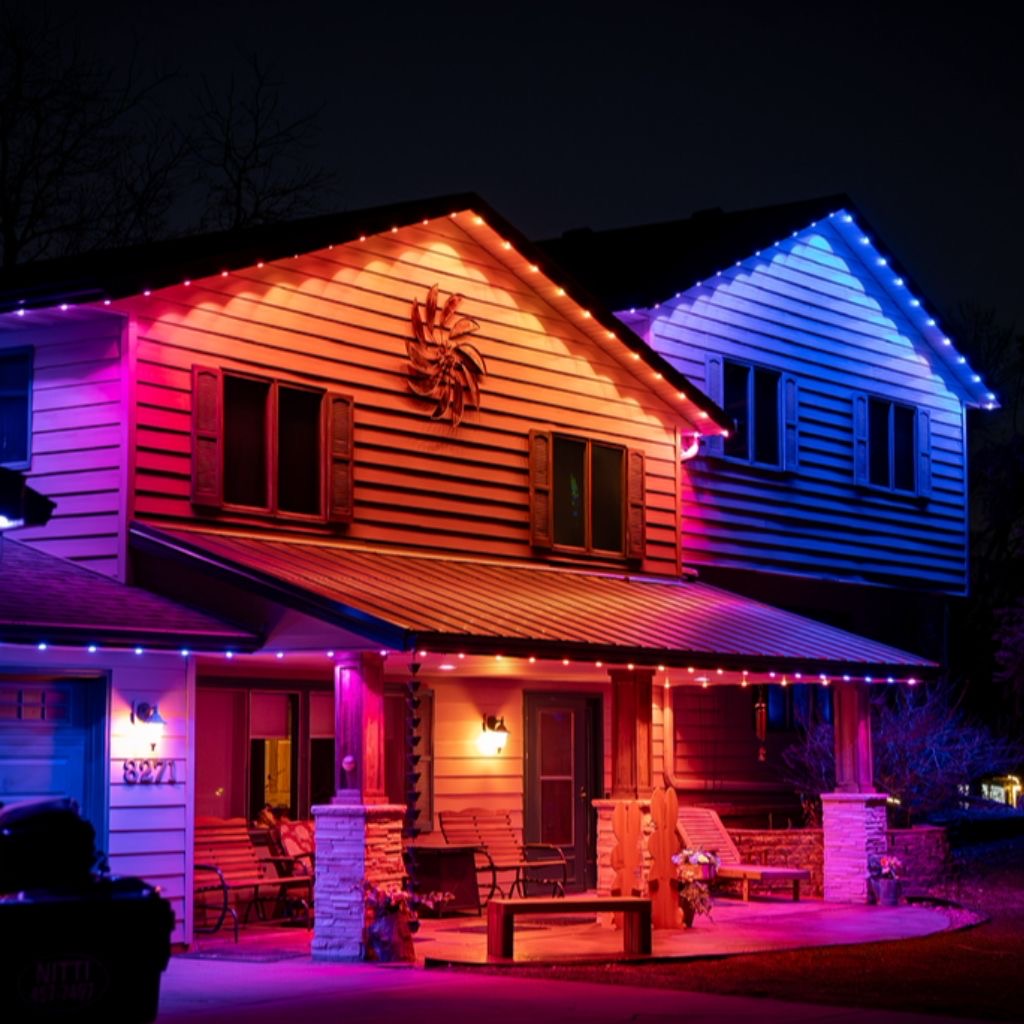 Craftsman home in vibrant pink, blue, and orange accent lighting